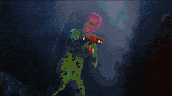 Character in green costume holding weapon.