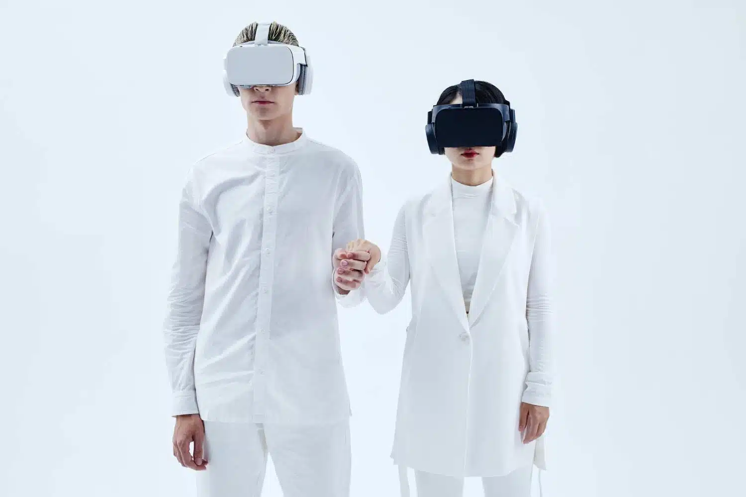 Two people in white outfits holding hands.