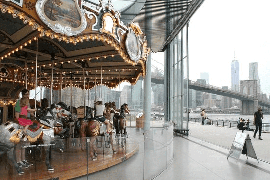 Carousel near city skyline and bridge
