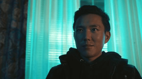 Person standing near turquoise curtains.
