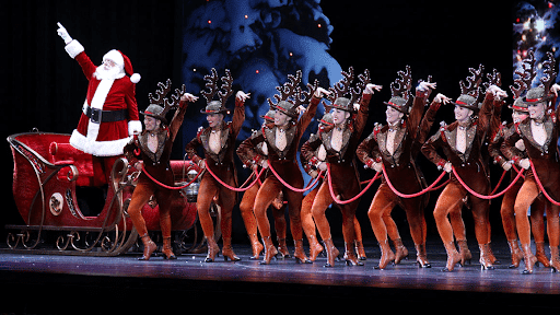 Santa with dancers in festive costumes